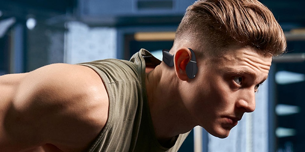 Słuchawki bezprzewodowe Creative Outlier Free Plus Bluetooth 5.3 szaro-zielone  widok na mężczyznę w słuchawkach